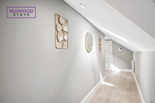 a hallway with white walls and a staircase with mirrors at Top Quality 2 Bed 1 Bath Apartments For Contractors By REDWOOD STAYS in Reading