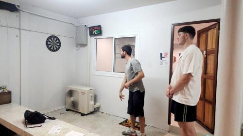 two men are standing in a room at No.9 Hostel kanchanaburi in Ban Don Rak
