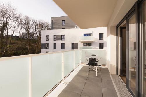 d'un balcon avec une table et une vue sur un bâtiment. dans l'établissement Rohan - T3 - parking - calme - wifi, à Vannes