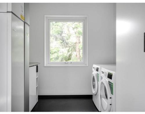 a kitchen with a washing machine and a window at Three Bedroom Villa Segersjö in Tumba