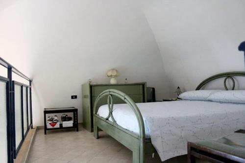 ein Schlafzimmer mit einem Bett mit einem grünen Rahmen in der Unterkunft Casa Rosa Atrani in Atrani