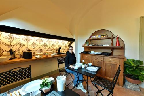a woman sitting at a bar in a restaurant at In Costa Relais & Luxury Suites in Vietri sul Mare