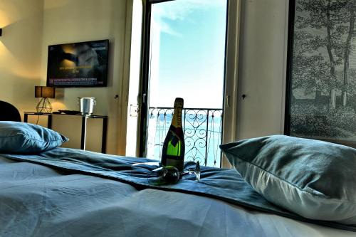 a bottle of wine sitting on top of a bed at In Costa Relais & Luxury Suites in Vietri sul Mare