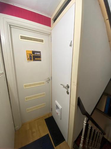 a hallway with a white door with a sign on it at Le gîte du Palayau in Bastogne