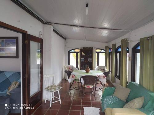 ein Wohnzimmer mit Tisch und Couch in der Unterkunft Casa no centro da cidade a 600 metros da praia. in Porto Belo