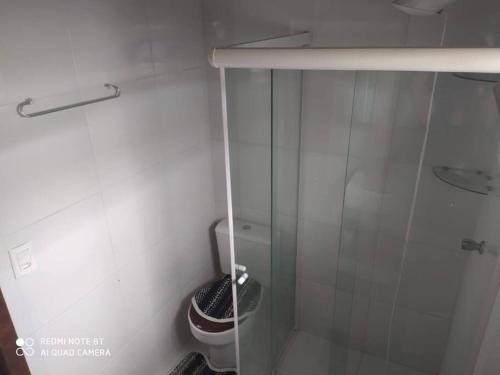 ein Badezimmer mit Toilette und Glasdusche in der Unterkunft Casa no centro da cidade a 600 metros da praia. in Porto Belo