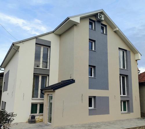 ein weißes und graues Gebäude mit Fenstern in der Unterkunft Apartmani Hub in Niš