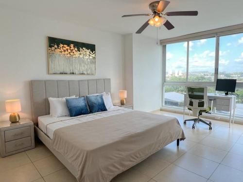 um quarto com uma cama, uma ventoinha de tecto e uma secretária em Alojamiento con vistas Costa del Este 1 na Cidade do Panamá