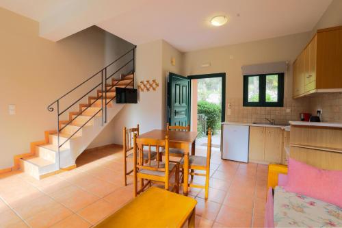 eine Küche und ein Wohnzimmer mit einem Tisch und Stühlen in der Unterkunft Vivi's Apartments in Ayia Evfimia