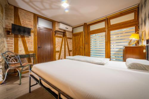 a bedroom with a bed and a chair and window at Guest house Diabora-Veliko Tarnovo in Veliko Tŭrnovo