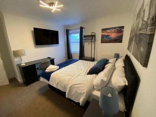 a bedroom with a large bed and a television at Huge 6 Bed house & 6 Bathrooms. in Boston
