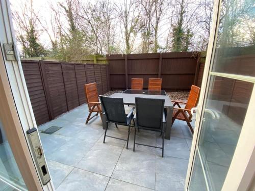 a patio with a table and chairs and a fence at Huge 6 Bed house & 6 Bathrooms. in Boston