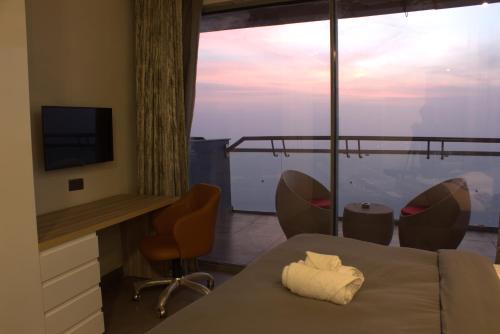 una stanza con tavolo e sedie e una grande finestra di AmigosStay - High Rise Studio with river view. a Noida