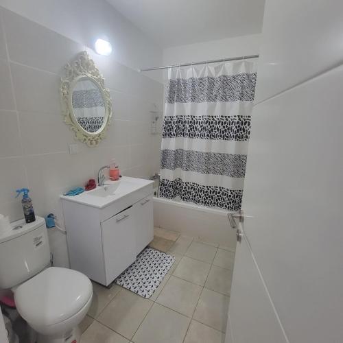 a white bathroom with a toilet and a shower at וילה ברמה in Beit Shemesh