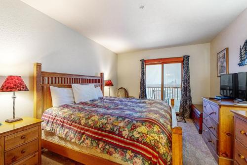 a bedroom with a bed and a tv and a window at Tenderfoot Lodge 2652 in Keystone