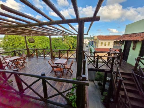 una terraza de madera con mesas y sillas. en Pousada Dunas Natal, en Natal