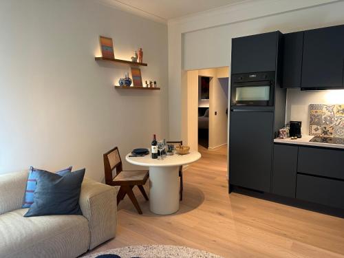 a living room with a couch and a table in a kitchen at Home away from home by the beach in Ostend