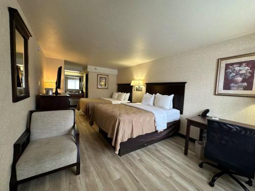 a hotel room with a large bed and a chair at Wingate by Wyndham Gunnison Near Western Colorado University in Gunnison