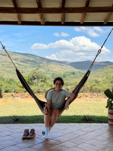 a woman sitting in a hammock with a view at Hotel Palais Barichara in Barichara