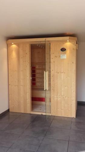 a room with a glass door in a building at gîte composé de 2 maisons avec cheminée et sauna in Houdetot