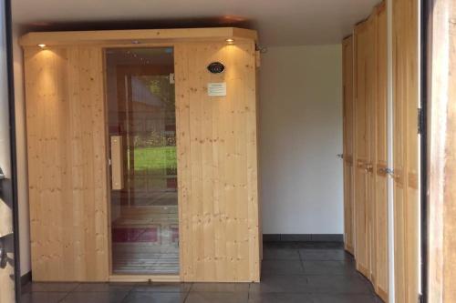 a row of wooden doors in a room at gîte composé de 2 maisons avec cheminée et sauna in Houdetot