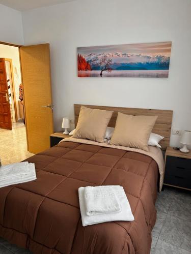 um quarto com uma cama grande com duas toalhas em Apartamento en Los cristianos 2 habitaciones 4 huespedes Vv Elenita em Los Cristianos