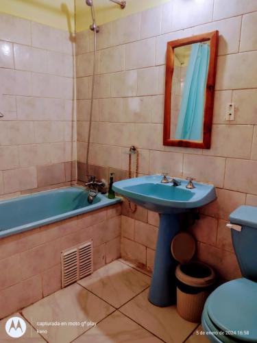 y baño con lavabo azul y bañera. en Hospedaje familiar rural, en Quellón