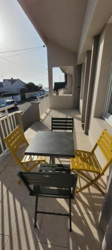 un patio avec deux chaises et une table sur un balcon dans l'établissement T3 “Belle-île“- 50 m de la plage de Fort Bloqué/Ploemeur, à Ploemeur