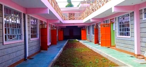 an empty hallway of a building with colorful doors at Njata Country House in Oljoro Orok