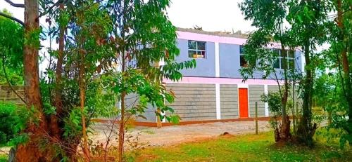 a house with a large garage with at Njata Country House in Oljoro Orok