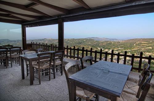 a table and chairs on a balcony with a view at Earino in Kato Asites