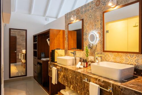 a bathroom with two sinks and a large mirror at The Beachfront by The Fives Hotels in Playa del Carmen