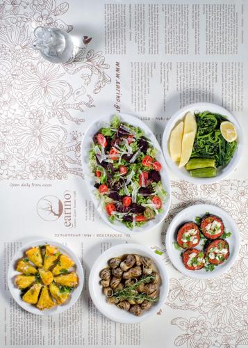 a table with three plates of food and a salad at Earino in Kato Asites