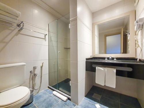 a bathroom with a toilet and a glass shower at Suite Confort - Gramado Wish Serrano in Gramado