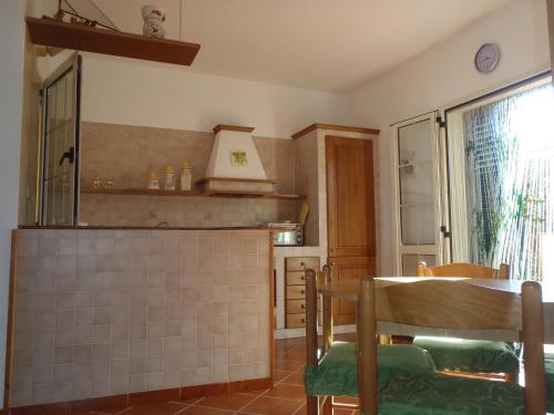 een keuken met een tafel, een spiegel en een raam bij Villa Milena in Marzamemi