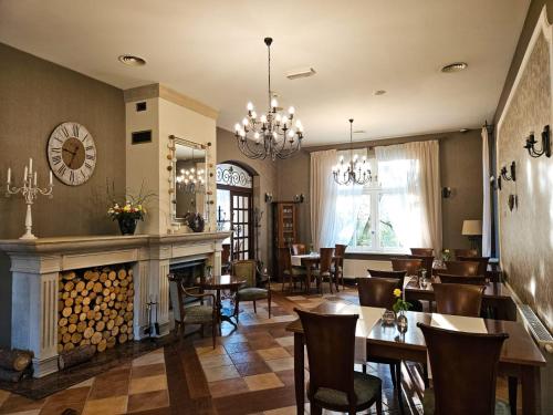 un restaurante con chimenea, mesas y sillas en Versant Hotel & Spa, en Dzierżoniów