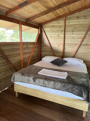 Bett in einem Zimmer in einer Holzhütte in der Unterkunft Popochos Beach Eco-Lodge in Nuquí