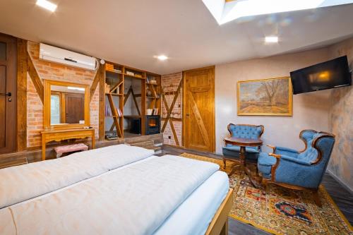 a bedroom with a bed and a chair and a television at Guest house Diabora-Veliko Tarnovo in Veliko Tŭrnovo