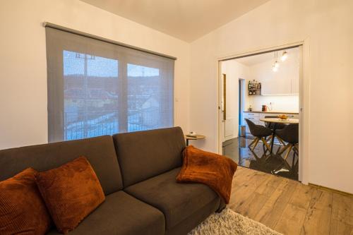 a living room with a couch and a kitchen at Viktória Vendégház in Eplény