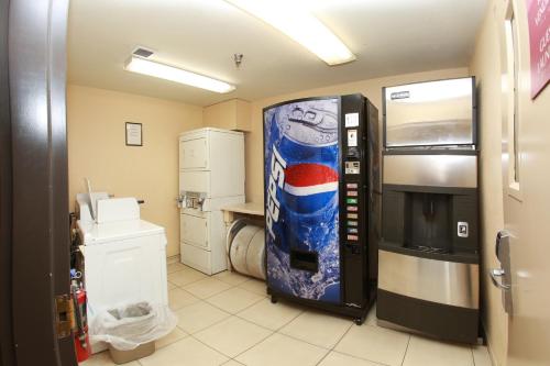 um quarto com uma máquina de venda automática de refrigerantes numa cozinha em Ramada by Wyndham Fresno Northwest em Fresno