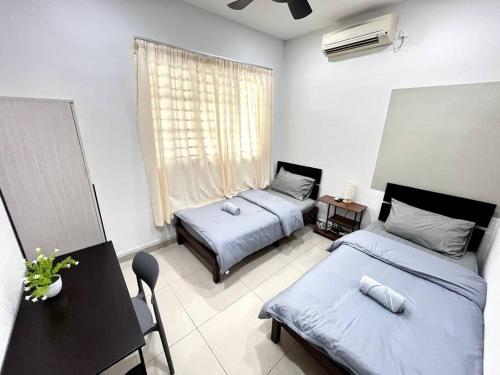 1 dormitorio con 2 camas, mesa y ventana en Pelangi Indah @ near JB AUSTIN #BBQ#KTV en Ulu Tiram