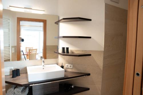 W łazience znajduje się umywalka i lustro. w obiekcie Haus Winkler w mieście Vilpiano