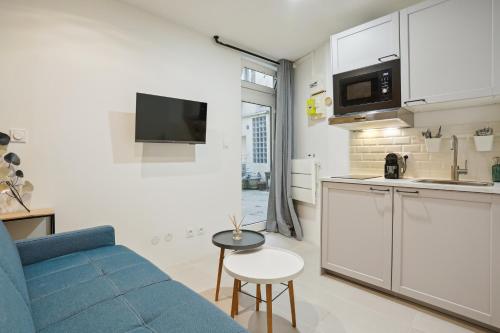 巴黎的住宿－Tiny Suite 12 D Paris’s heart!，一间带蓝色沙发的客厅和一间厨房