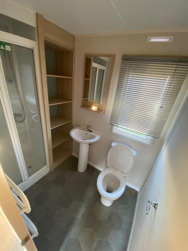 La salle de bains est pourvue de toilettes et d'un lavabo. dans l'établissement Hillside Sleeps 6, à Allhallows