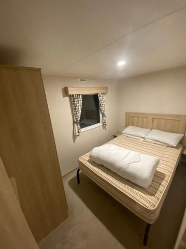 - un petit lit dans une chambre avec fenêtre dans l'établissement Hillside Sleeps 6, à Allhallows