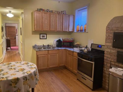 a kitchen with wooden cabinets and a table in a room at Queen Bed w private ensuite bathroom in Lakeview - 3d in Chicago