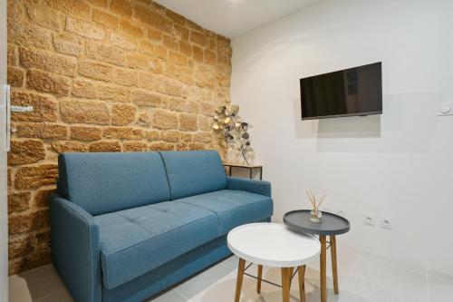 巴黎的住宿－Tiny Suite 12 D Paris’s heart!，客厅设有蓝色的沙发和砖墙