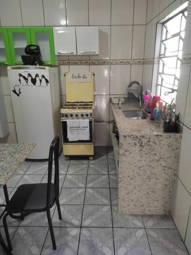 una pequeña cocina con fogones y fregadero en Gray House 3 - JD. Leonor en Londrina
