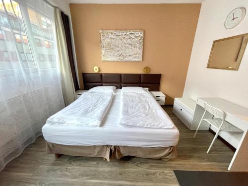 Schlafzimmer mit einem Bett, einem Schreibtisch und einem Fenster in der Unterkunft Stylish home near city center in Wien