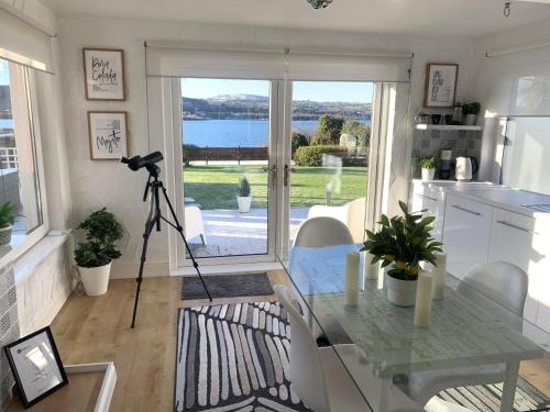 eine Küche mit einem Glastisch und einer Kamera in der Unterkunft Seaview Cottage on the Island 